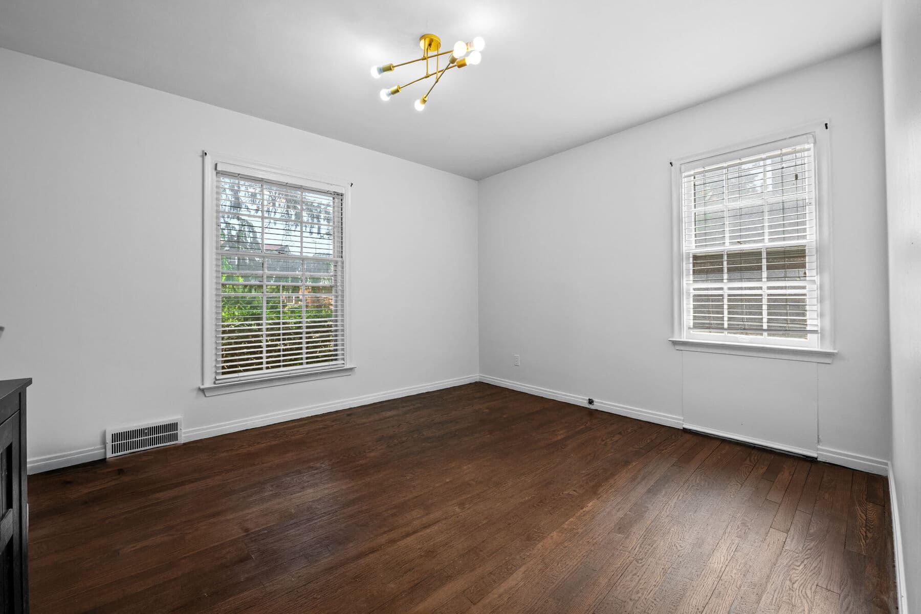Bright main-level bedroom with hardwood floors and two windows at 3963 Yorkshire