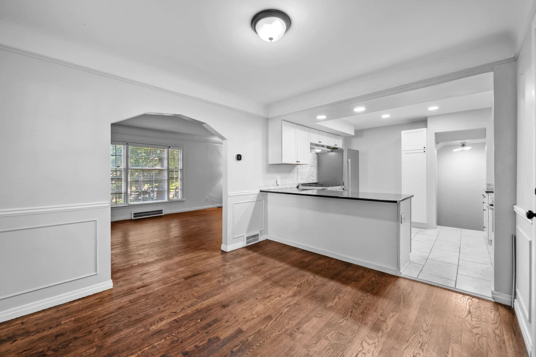 Dining room with wainscoting and an arched doorway opening to the updated kitchen at 3963 Yorkshire