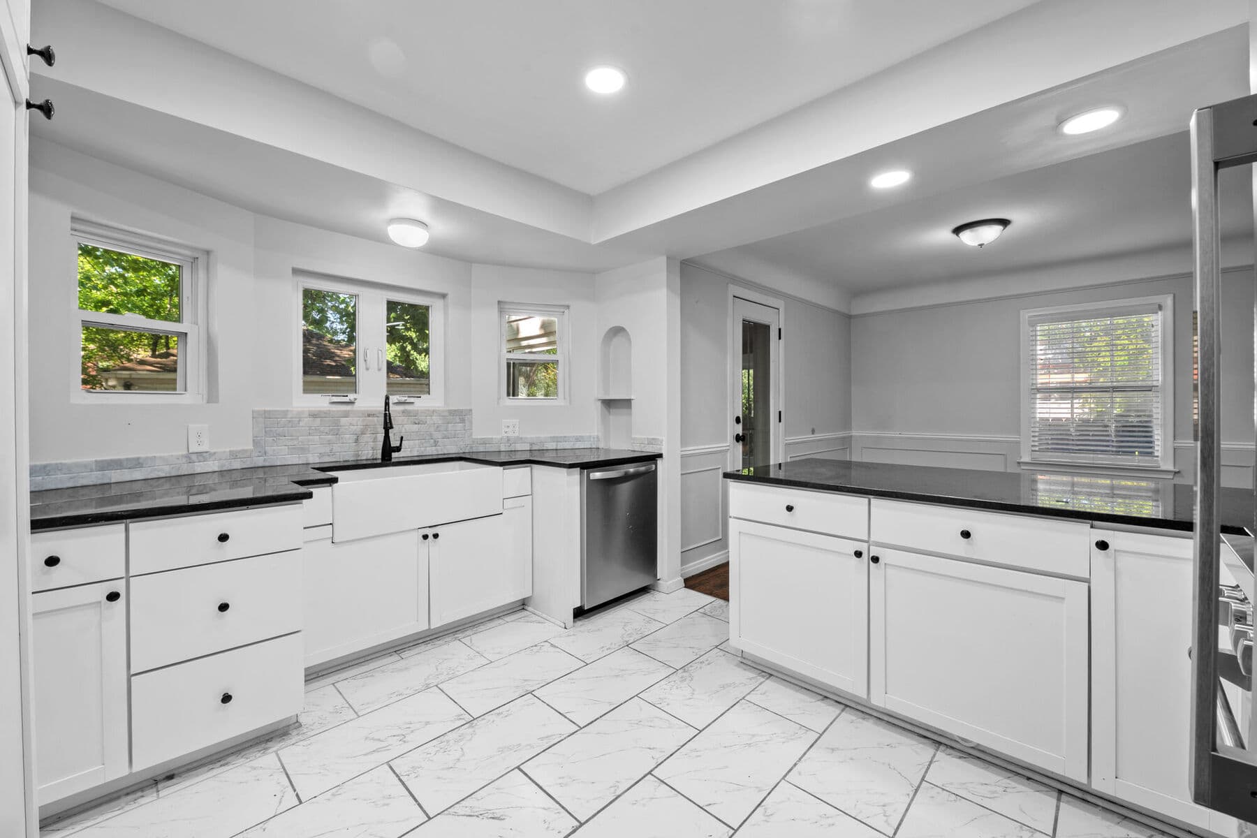 Kitchen with farmhouse sink beneath windows and stainless dishwasher at 3963 Yorkshire