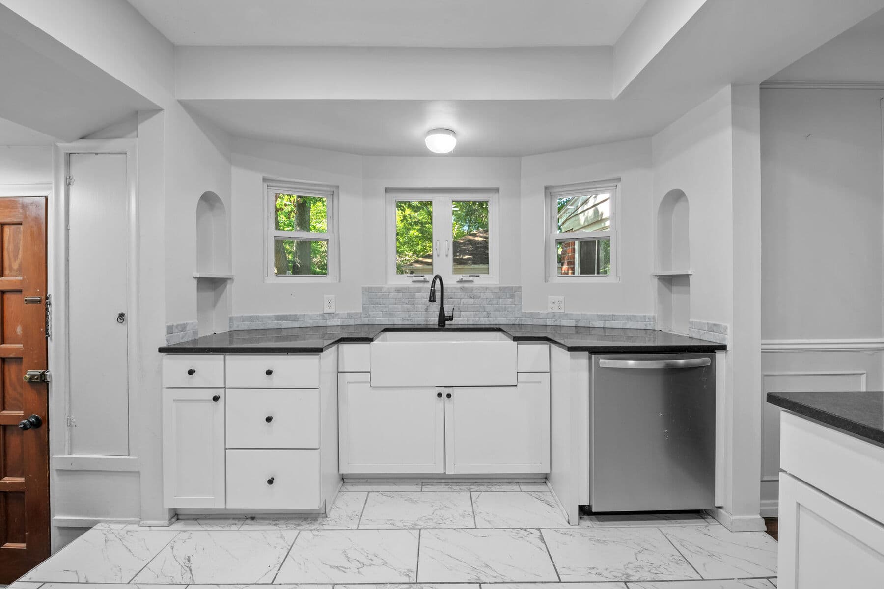 Farmhouse sink framed by arched built-in niches and windows in the kitchen at 3963 Yorkshire