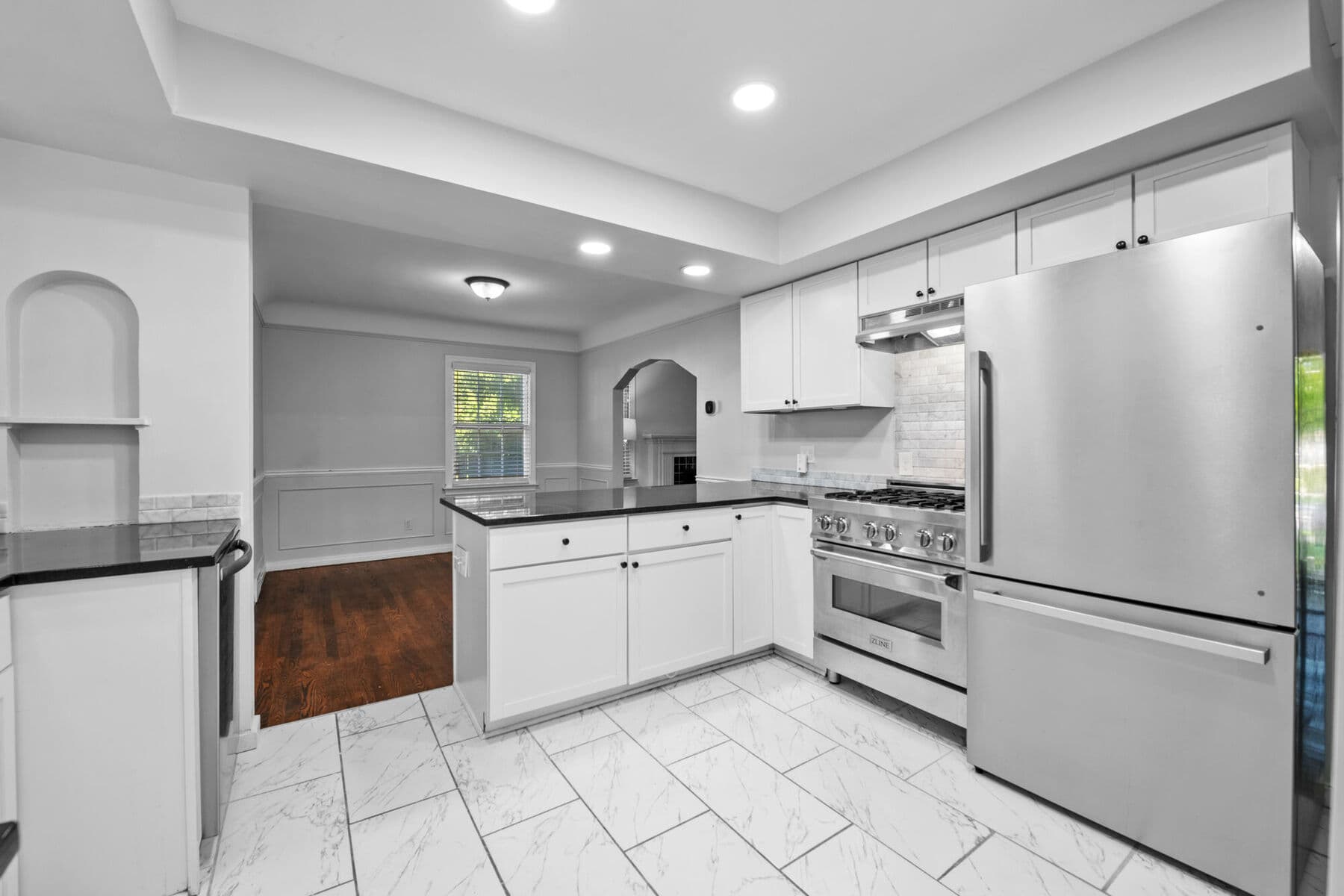 Updated kitchen with white shaker cabinets, stone countertops and stainless steel appliances at 3963 Yorkshire, East English Village