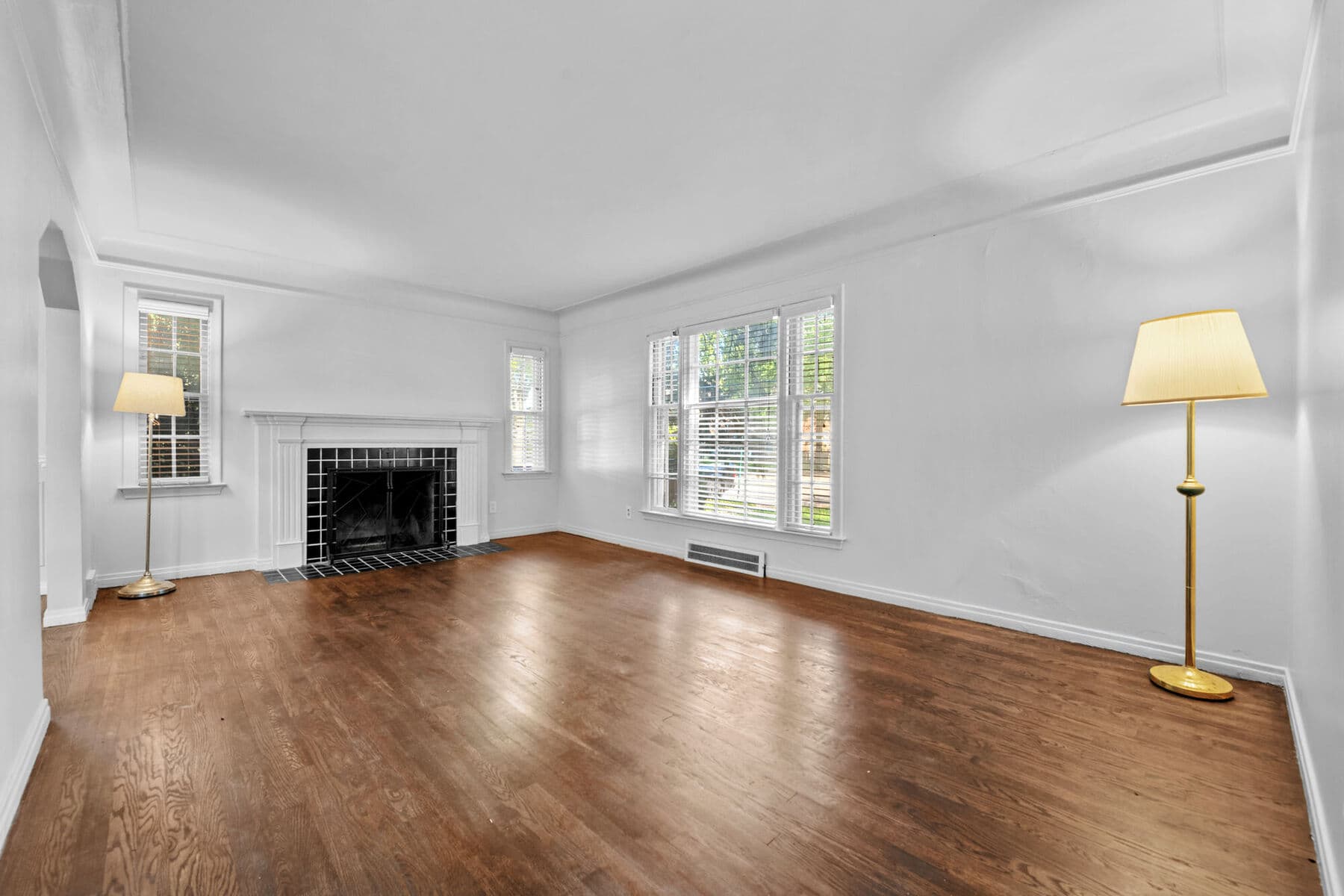 Sunlit living room with hardwood floors, crown molding and a tiled fireplace at 3963 Yorkshire in East English Village