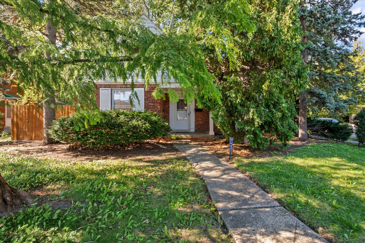 Front walk and wood privacy fence framed by mature evergreens at 3963 Yorkshire, East English Village