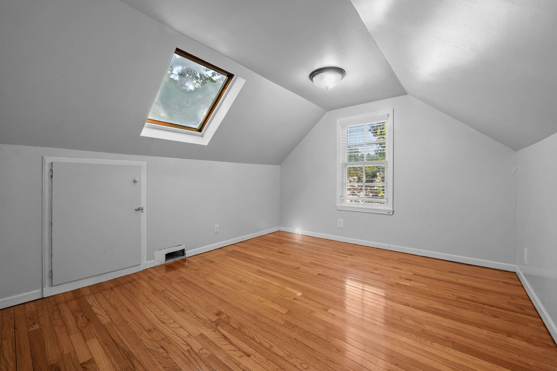 Primary suite sitting area with skylight and hardwood floors at 3963 Yorkshire